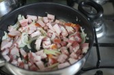Na oleju podsmażam cebulę, gdy jest szklista, to wrzucam czosnek, dodaję troszkę soli, by zatrzymać proces karmelizacji, wrzucam boczek, szynkę i podsmażam. Podsmażam, aż będą rumiane. Dodaję mięso i obsmażam.